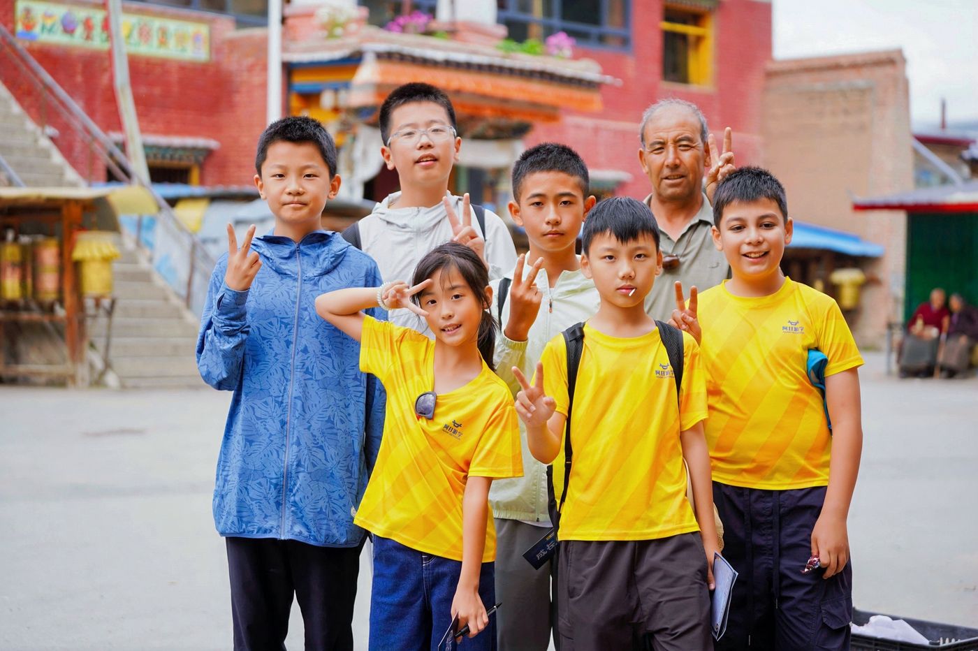 孩子们在村寨里与当地老人合影