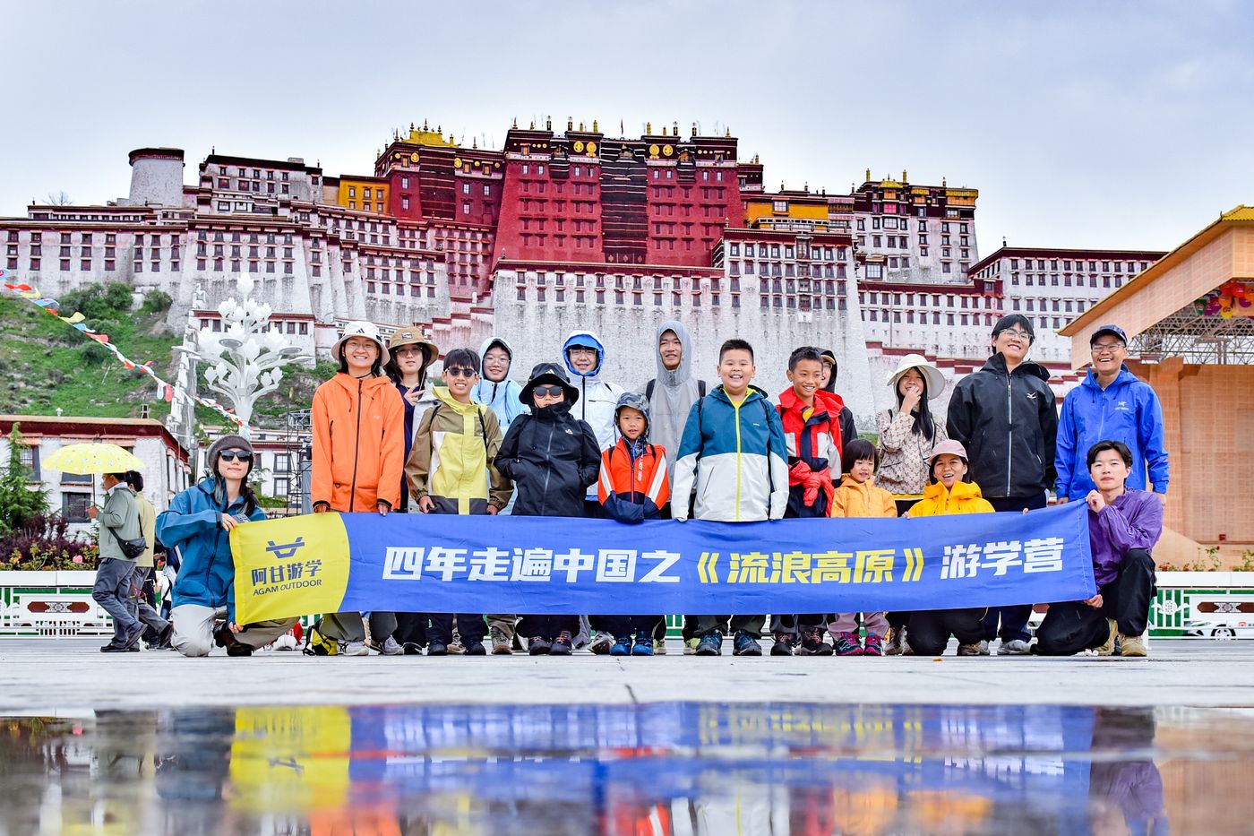 阿甘游学流浪高原营在布达拉宫广场前的结营合影，孩子们举着营旗