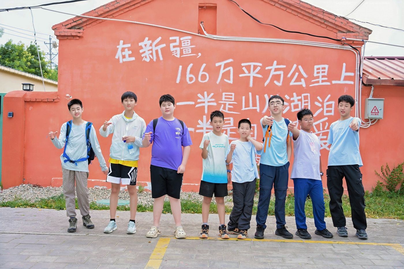 孩子们在新疆一处红墙前合影